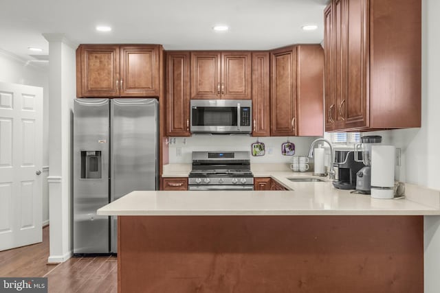 2124 Weber Dr, District Heights, MD 20747 - kitchen with a sink, stainless steel appliances, light countertops, a peninsula, and dark wood-type flooring