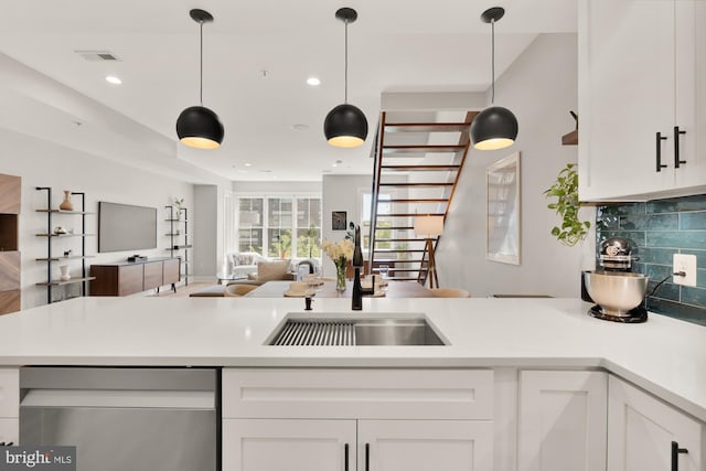 kitchen featuring visible vents, dishwasher, a sink, open floor plan, and white cabinetry