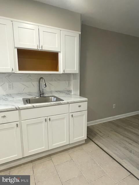 5621 Springfield Ave, Philadelphia, PA 19143 - kitchen with white cabinetry, backsplash, light tile patterned floors, and a sink