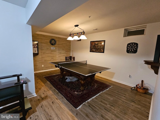 playroom with baseboards, wood walls, wood finished floors, and visible vents