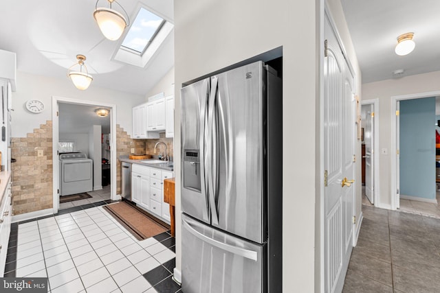 kitchen featuring washer / clothes dryer, a sink, appliances with stainless steel finishes, and tile patterned floors