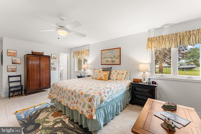 bedroom featuring baseboards, a ceiling fan, and light tile patterned flooring
