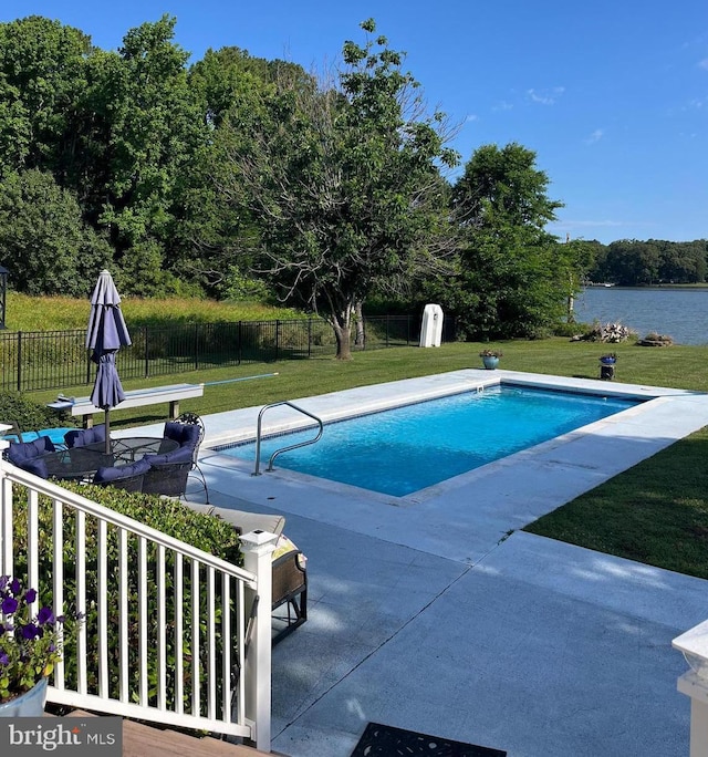 view of pool featuring fence, a fenced in pool, a water view, a patio area, and a yard