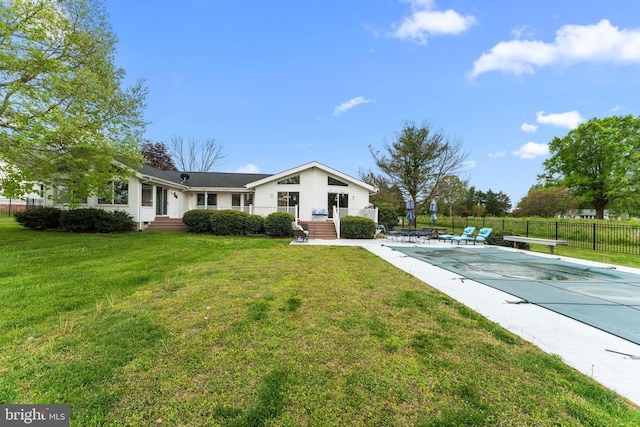 view of front of property with fence, a fenced in pool, and a front lawn