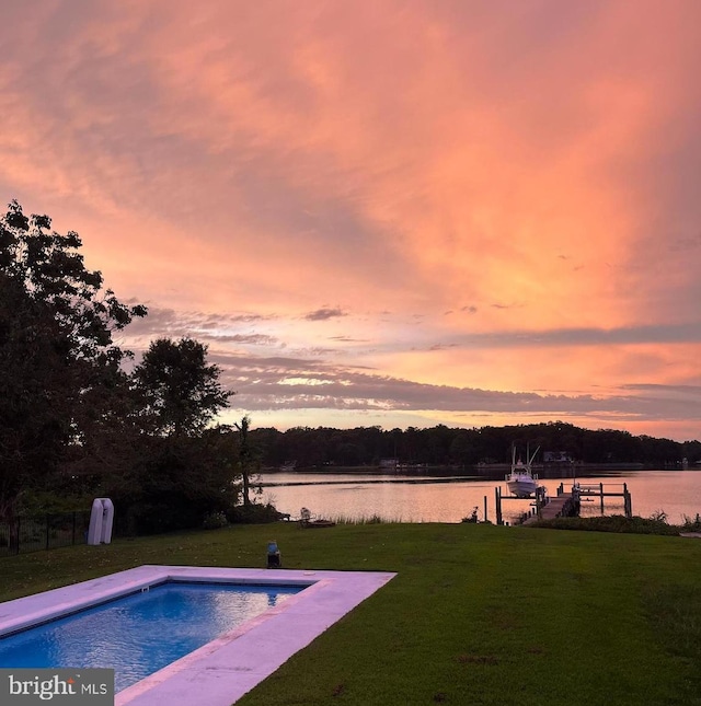 outdoor pool featuring a lawn, a water view, and a dock