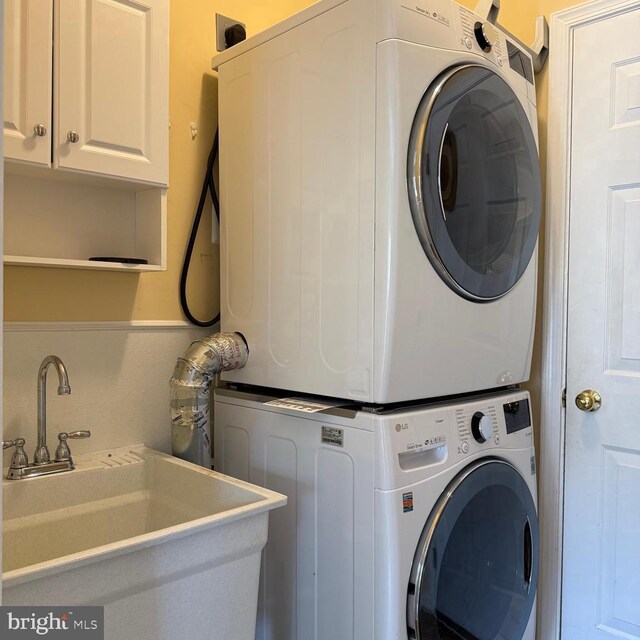 103 Claude Ct SE, Leesburg, VA 20175 - laundry room featuring cabinet space, stacked washer and dryer, and a sink