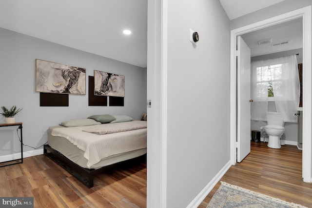 bedroom with visible vents, baseboards, and wood finished floors