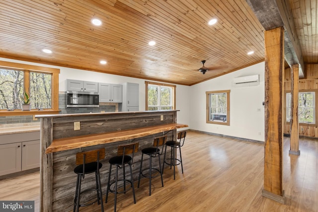 275 Oak Forest Ln, Berkeley Springs, WV 25411 - kitchen featuring an AC wall unit, stainless steel microwave, lofted ceiling, gray cabinets, and wooden ceiling