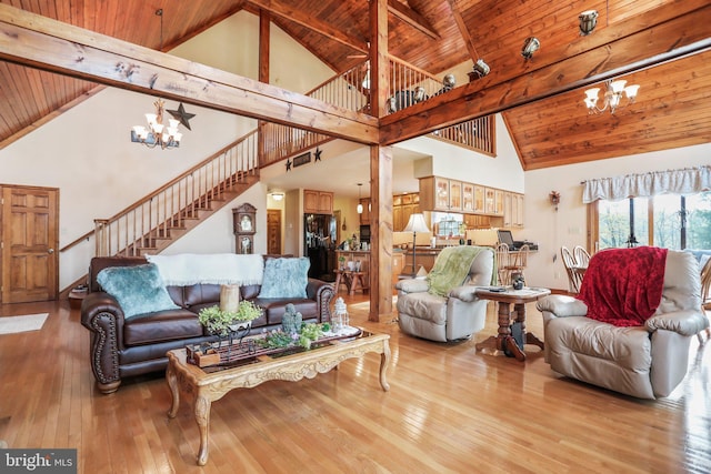 living area featuring wooden ceiling, high vaulted ceiling, and a chandelier