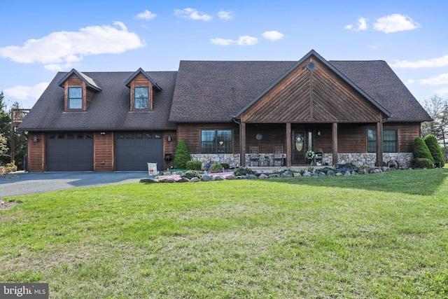 view of front of home featuring a garage, stone siding, a front yard, and aphalt driveway