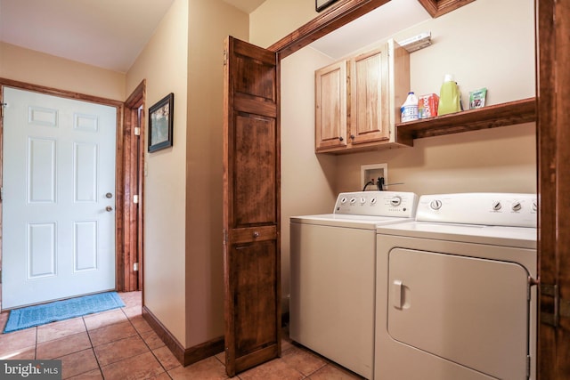 washroom with cabinet space, independent washer and dryer, baseboards, and light tile patterned floors