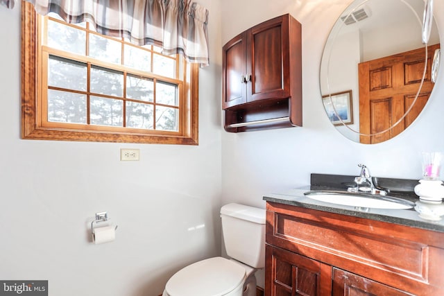 bathroom featuring vanity, toilet, and visible vents