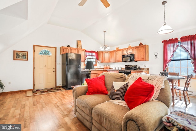 living area featuring light wood-style floors, baseboards, ceiling fan, and lofted ceiling