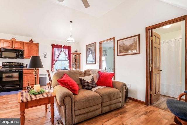 living room with ceiling fan, lofted ceiling, and light wood-type flooring