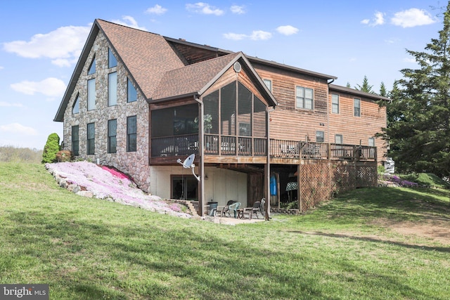 back of property featuring roof with shingles, a sunroom, a deck, a patio, and a yard