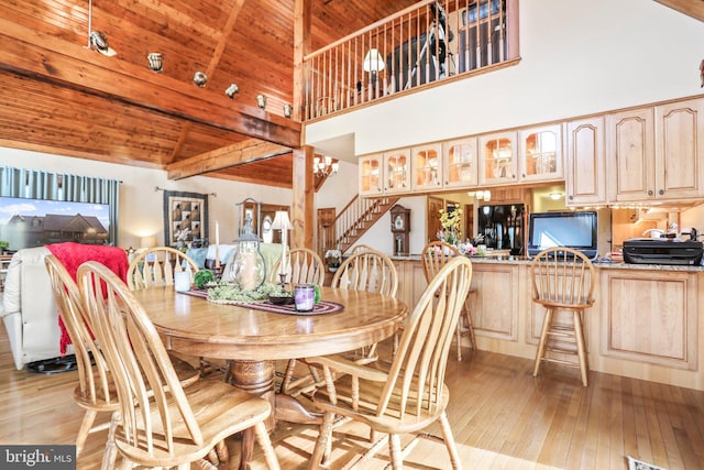 dining space with high vaulted ceiling, light wood-style flooring, stairs, wooden ceiling, and beamed ceiling