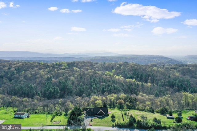 birds eye view of property featuring a wooded view and a mountain view