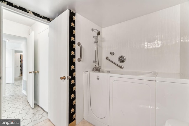 laundry area with laundry area, washer / dryer, and light tile patterned flooring