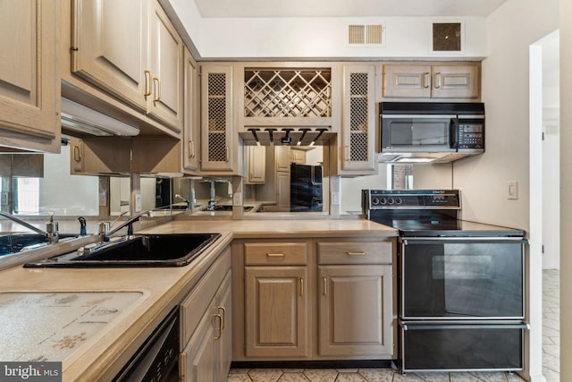 kitchen with visible vents, a sink, black appliances, and light countertops