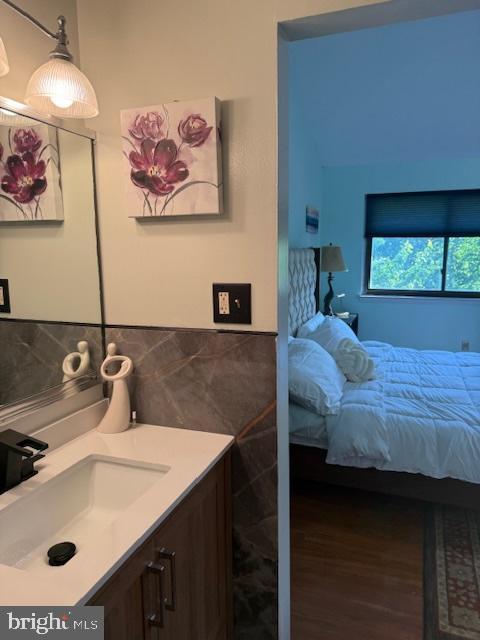 18413 Stone Hollow Dr, Germantown, MD 20874 - bedroom featuring a sink, wood finished floors, and tile walls