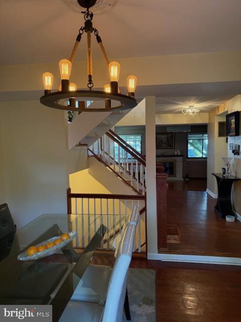 18413 Stone Hollow Dr, Germantown, MD 20874 - dining area with a chandelier, wood finished floors, a fireplace, and baseboards