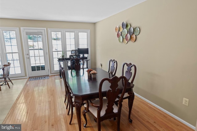 dining space with light wood finished floors, baseboards, and plenty of natural light