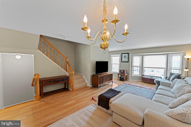 living area with stairway, wood finished floors, and a notable chandelier