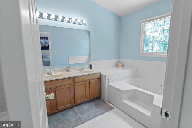 bathroom with double vanity, a bath, ensuite bath, and a sink