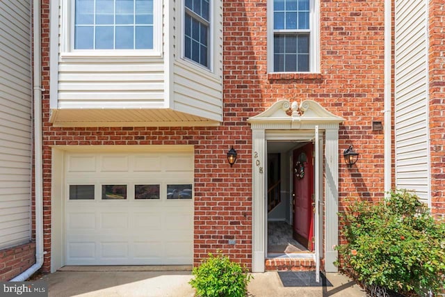 property entrance with brick siding and an attached garage