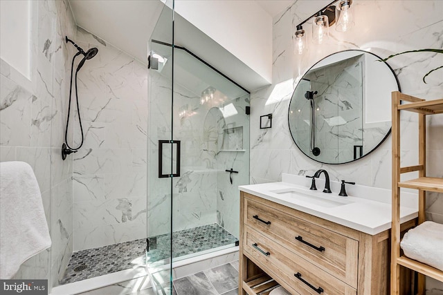 full bathroom featuring tile walls, marble finish floor, vanity, and a marble finish shower