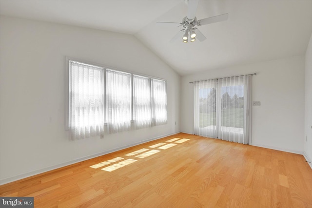unfurnished room featuring baseboards, ceiling fan, vaulted ceiling, and wood finished floors