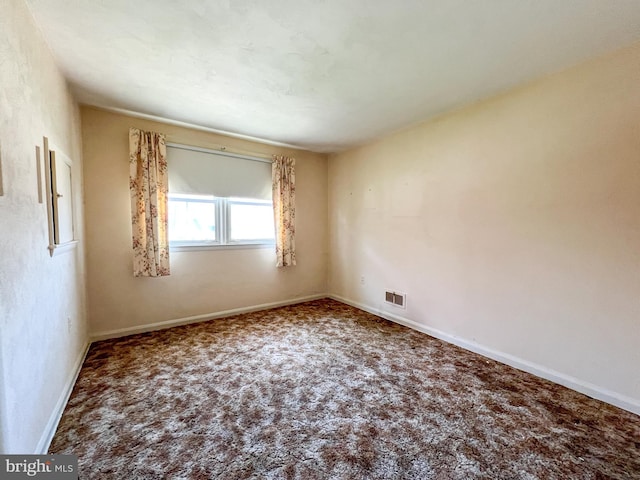 carpeted spare room with baseboards and visible vents