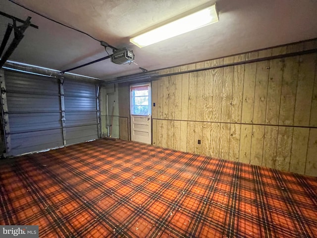 garage featuring wooden walls and a garage door opener