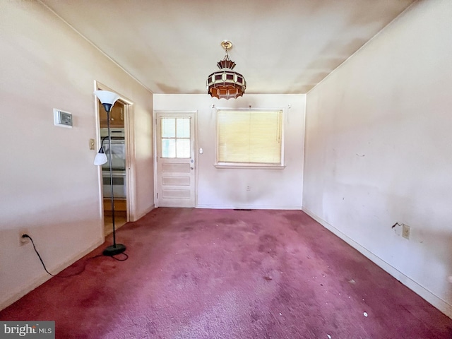 unfurnished dining area featuring baseboards and carpet flooring