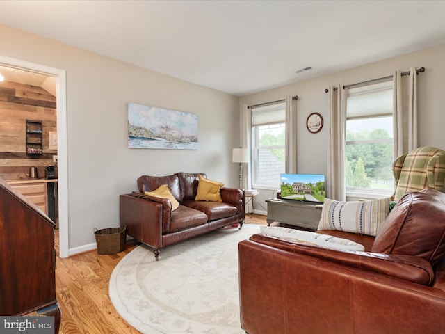 living area with visible vents and light wood-style floors