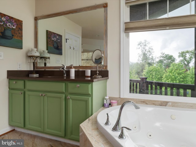 full bathroom with a tub with jets, a wealth of natural light, and vanity