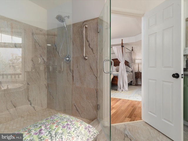 bathroom with ensuite bathroom, a marble finish shower, and wood finished floors