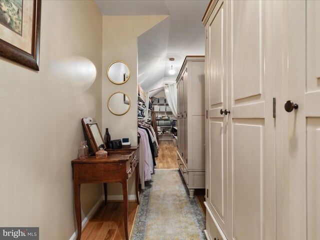 hall with baseboards and wood finished floors