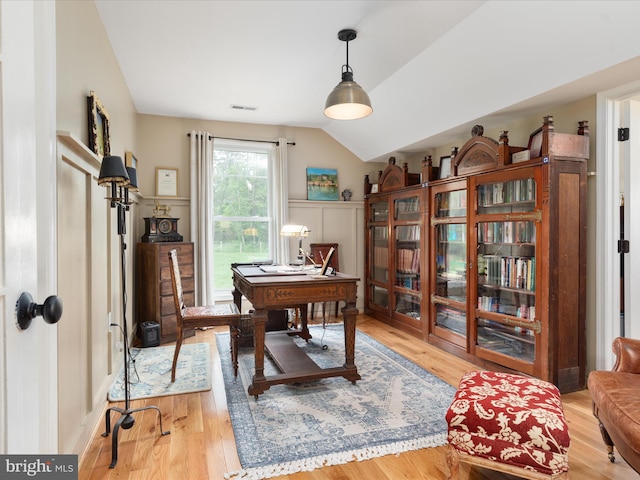 office with vaulted ceiling, visible vents, and wood finished floors