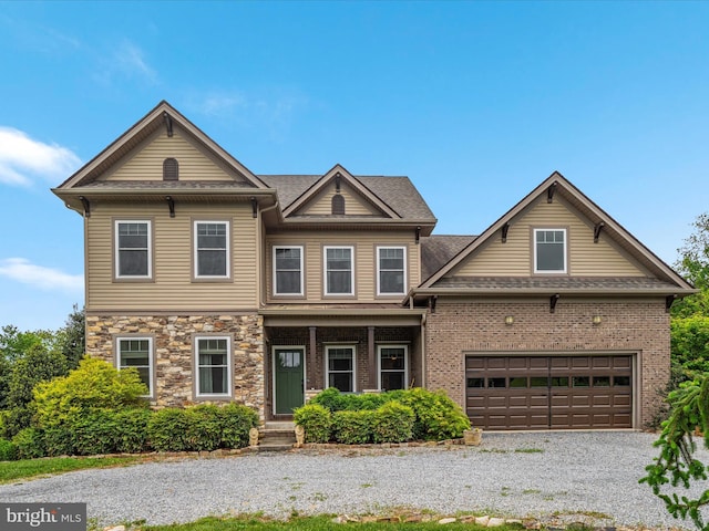 craftsman inspired home featuring a shingled roof, driveway, and a garage