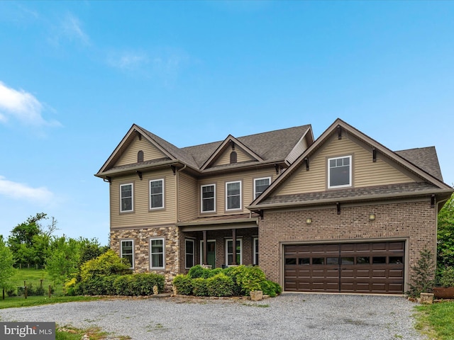 craftsman house with an attached garage and gravel driveway