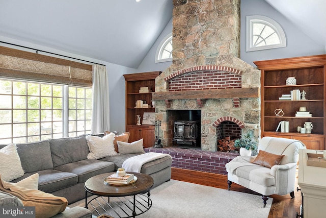 living room with wood finished floors, healthy amount of natural light, and high vaulted ceiling