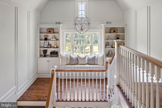 bedroom with a decorative wall, a chandelier, and lofted ceiling