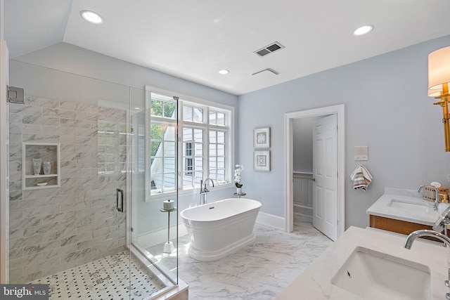 full bathroom featuring a stall shower, double vanity, a freestanding bath, recessed lighting, and baseboards
