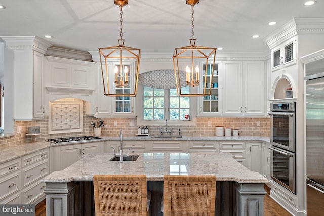 kitchen with a sink, stainless steel appliances, white cabinets, a chandelier, and recessed lighting