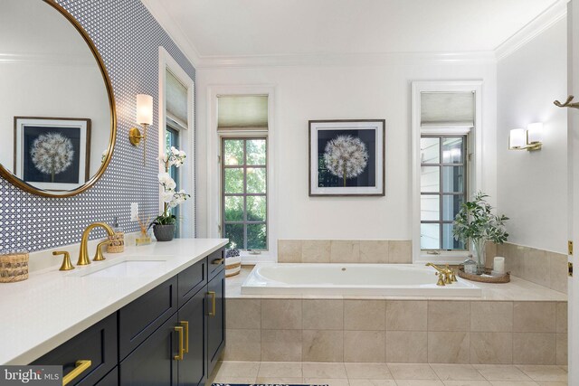 bathroom featuring a garden tub, crown molding, vanity, and tile patterned floors