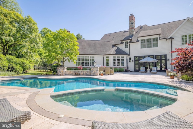 view of pool featuring a patio area and a pool with connected hot tub