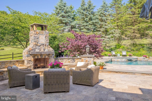 view of patio featuring an outdoor stone fireplace and an outdoor pool