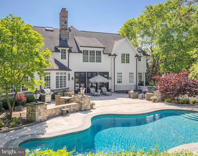 swimming pool featuring a patio and grilling area