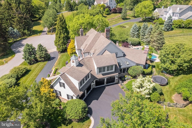 aerial view of property and surrounding area featuring a tree filled landscape